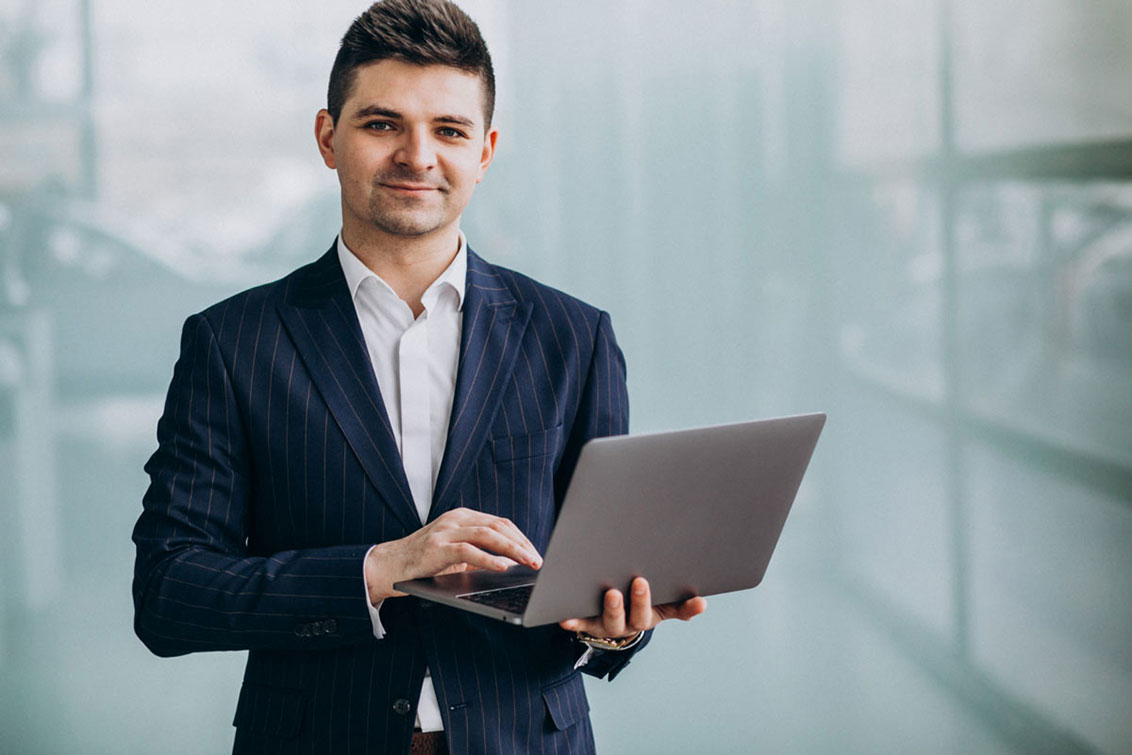 Photo of a man holding a laptop